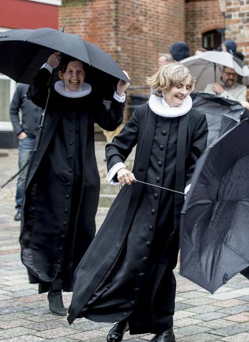 Billede af glade præster med paraply