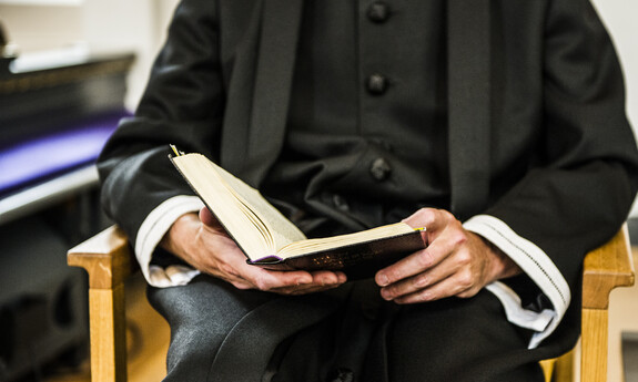 Billede af præst med alterbog i hånden