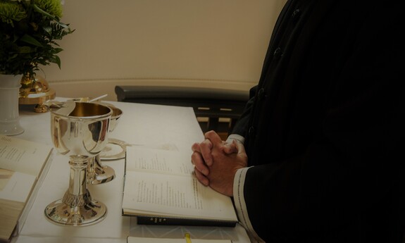 Billede af præst der beder ved alteret