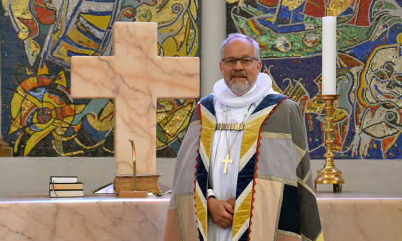 Billede af biskoppen i bispekåbe foran alterbordet i Ribe Domkirke